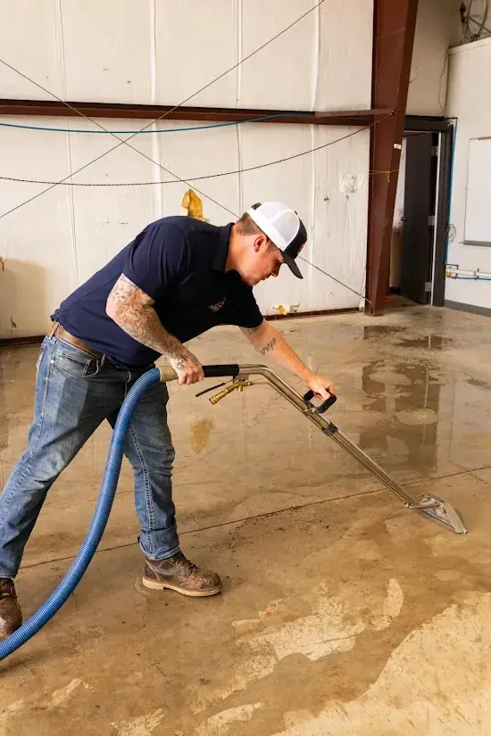 Technician extracting water from a slab leak on a Malibu floor